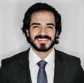 la imagen puede contener a un hombre vestido de traje,de cabello largo y barba,posa sonriente